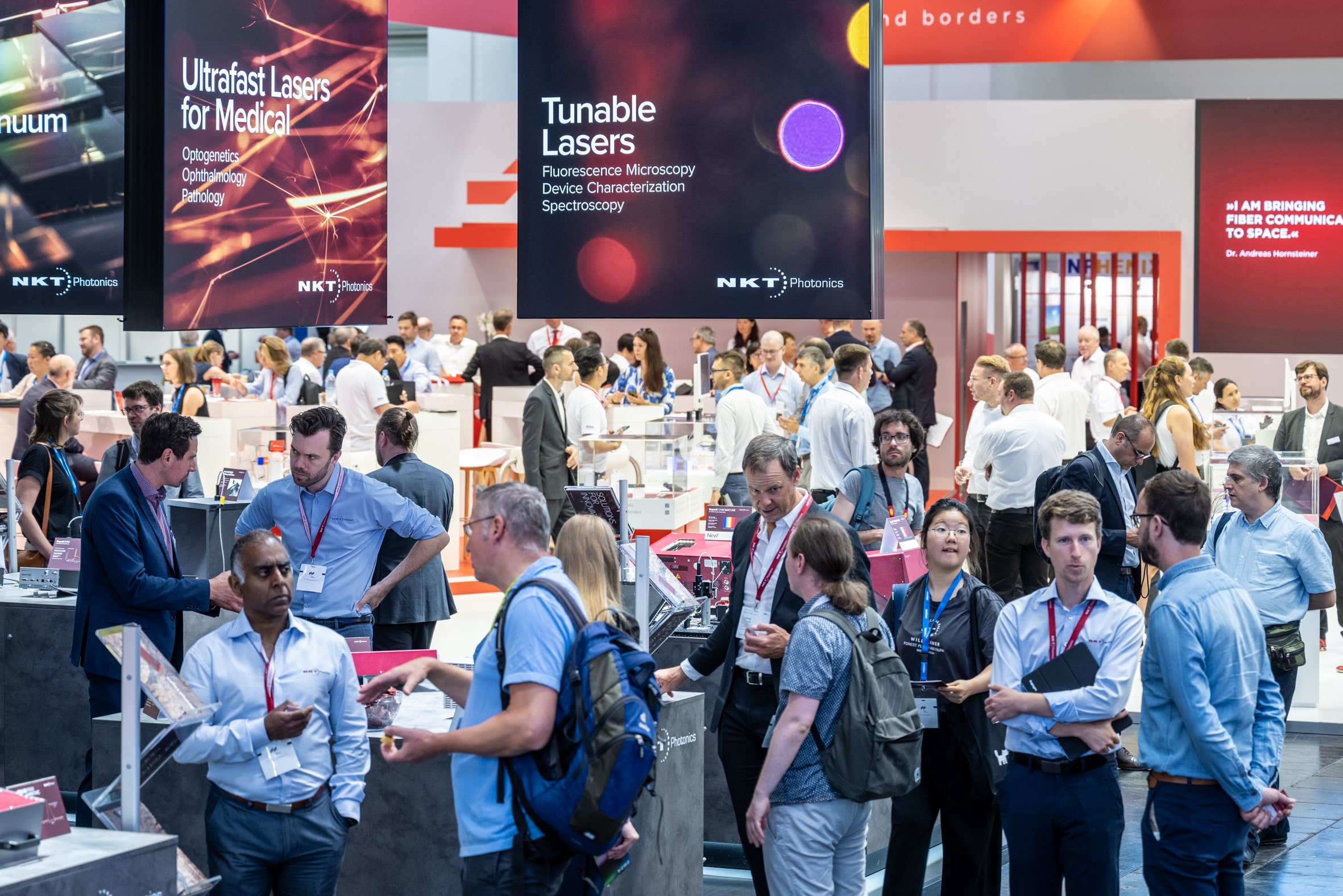 People networking and talking at a fair. Laser World of Photonics Fair and World of Photonics Congress 2025.